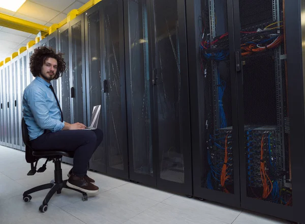 Engenheiro trabalhando em um laptop na sala do servidor — Fotografia de Stock