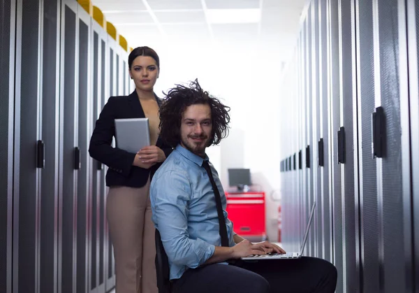 Equipo de jóvenes técnicos trabajando juntos en servidores — Foto de Stock