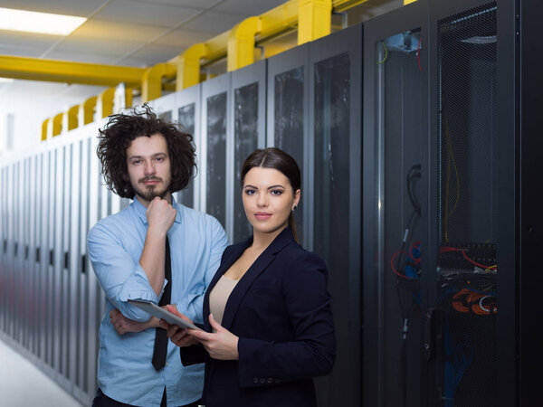 engineer showing working data center server room to female chief