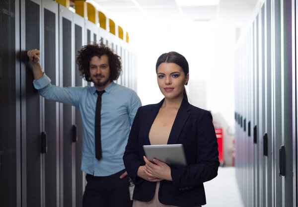 engineer showing working data center server room to female chief