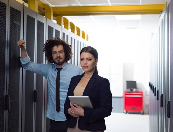 engineer showing working data center server room to female chief