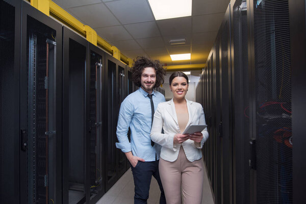engineer showing working data center server room to female chief