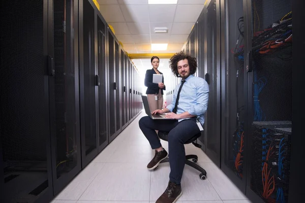 Equipe de jovens técnicos trabalhando juntos em servidores — Fotografia de Stock