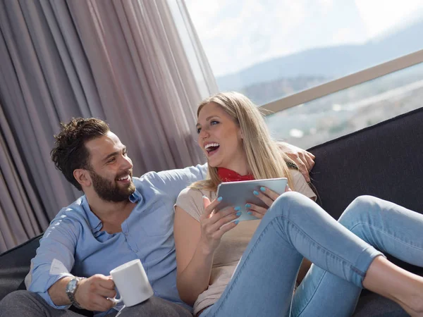 Pareja Joven Relajándose Casa Usando Tabletas Leyendo Sala Estar Sofá —  Fotos de Stock