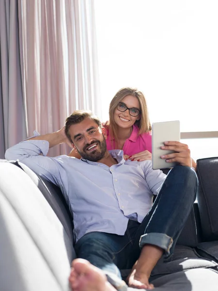 Mladý Pár Relaxovat Doma Pomocí Tabletu Počítače Čtení Obývacím Pokoji — Stock fotografie
