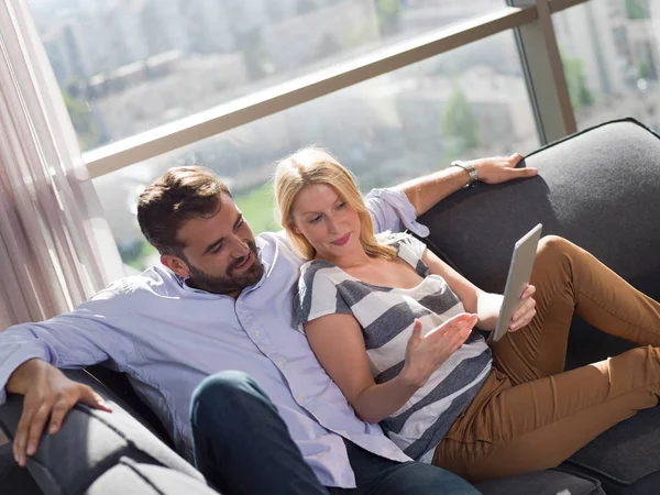 Pareja Joven Relajándose Casa Usando Tabletas Leyendo Sala Estar Sofá —  Fotos de Stock