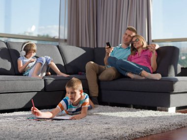 Mutlu genç aile oynarken birlikte evde bir tablet ve bir çocuk çizim kümesi kullanma