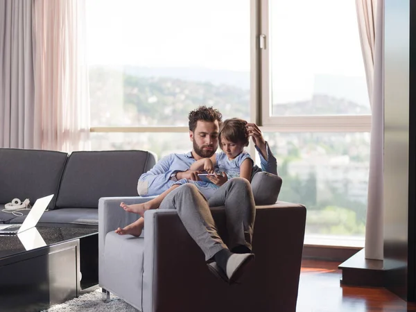 小女孩和她英俊的父亲使用数字平板电脑微笑 坐在沙发上在家 — 图库照片