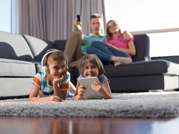 快乐的年轻家庭在家里玩耍 孩子们在地板上玩平板电脑 — 图库照片
