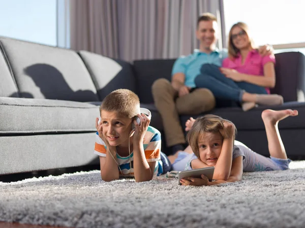 快乐的年轻家庭在家里玩耍 孩子们在地板上玩平板电脑 — 图库照片