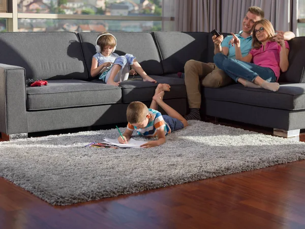 幸せな若い家族再生自宅を使用してタブレットと子供の図面セット — ストック写真