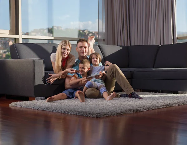 快乐的年轻家庭坐在沙发上和平板电脑一起玩 — 图库照片