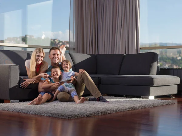 幸せな若い家族はソファに座って自宅でタブレットと一緒に遊ぶ — ストック写真