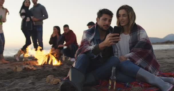 Pareja Disfrutando Hoguera Con Amigos Playa — Vídeo de stock