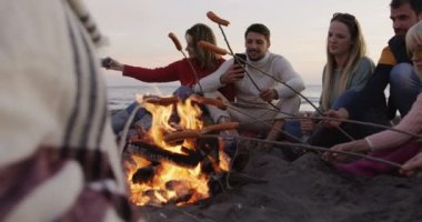 Bir grup genç arkadaş gecenin bir yarısı şöminenin başında oturuyor.