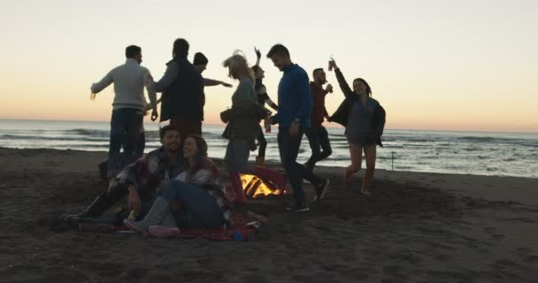 Groep Vrienden Dansend Rond Kampvuur Het Strand Bij Zonsondergang — Stockvideo