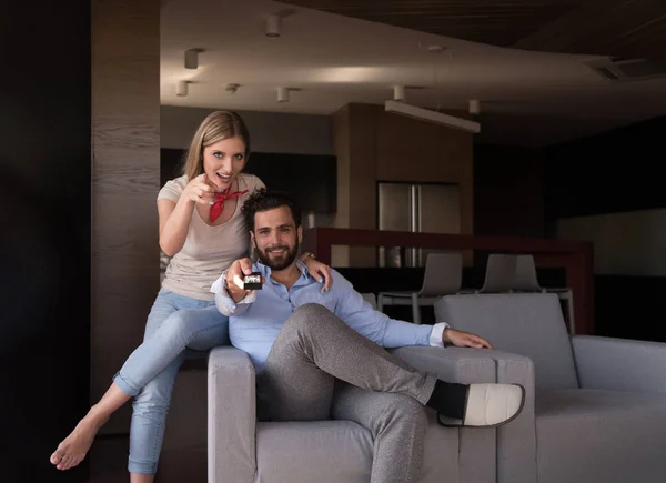 Jovem casal no sofá assistindo televisão — Fotografia de Stock