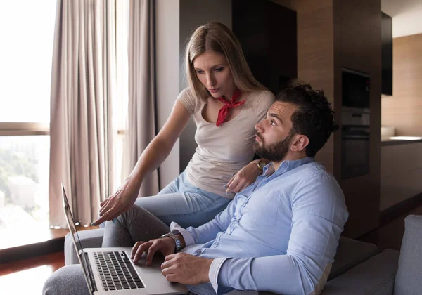 Pareja relajándose en casa usando computadoras portátiles —  Fotos de Stock