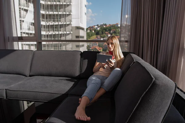 Jonge vrouw op de Bank thuis surfen web — Stockfoto