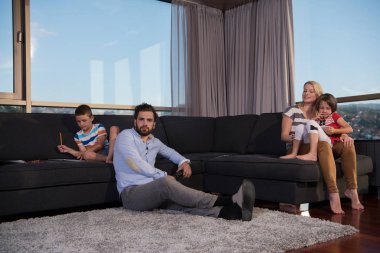 Mutlu Genç Aile Evdeki kanepede birlikte oynuyorlar Bir tablet ve bir çocuk çizim seti kullanarak