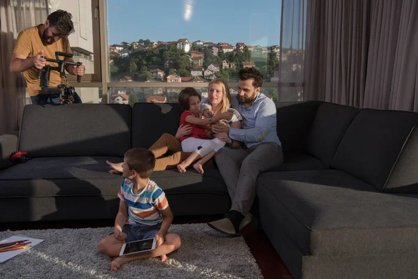 幸せなカップルは子供たちと一緒に家でソファーでタブレットを使って — ストック写真