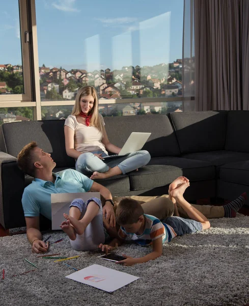 Jovem Família Feliz Brincando Juntos Casa Chão Usando Computador Portátil — Fotografia de Stock