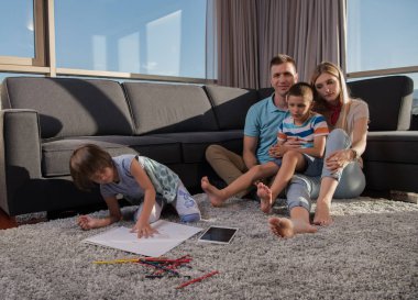 Mutlu Genç Aile, tablet ve çizim setiyle evde birlikte oynuyor.