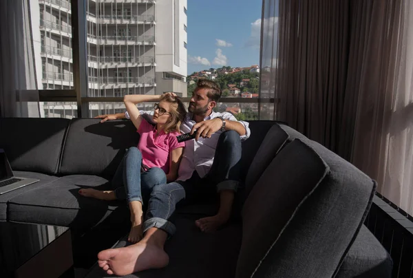 Young couple sitting on sofa — Stock Photo, Image