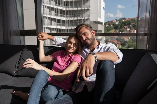 Mladý pár sedí na pohovce — Stock fotografie