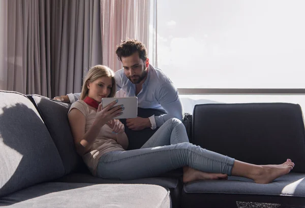Пара отдыха дома с помощью планшетного компьютера — стоковое фото