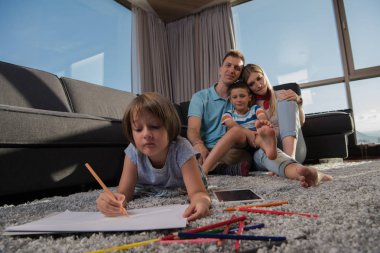 Mutlu Genç Aile, tablet ve çizim setiyle evde birlikte oynuyor.