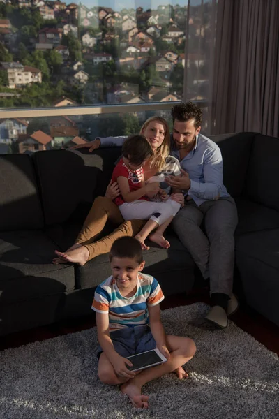 Happy young couple spending time with kids at home — Stock Photo, Image