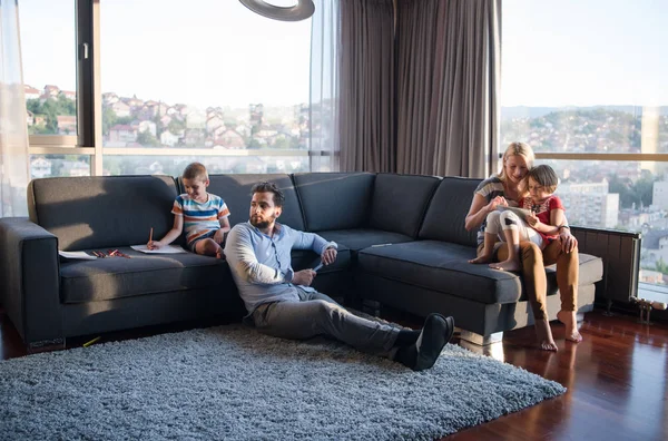 幸せな若い家族がタブレットと子供の絵セットを使用して自宅でソファで一緒に遊ぶ — ストック写真