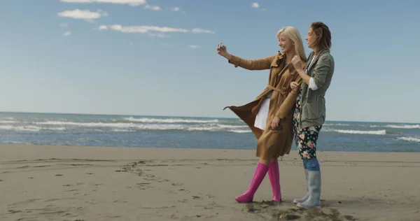 Két Mosolygó Fiatal Így Selfie Mobiltelefon Őszi Nap Strandon — Stock Fotó