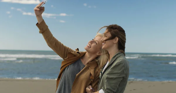 Duas Jovens Mulheres Sorrindo Fazendo Selfie Celular Dia Outono Praia — Fotografia de Stock