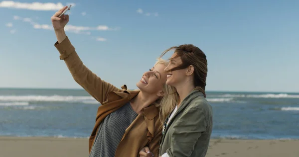 Twee Jonge Vrouwen Selfie Maken Mobiele Telefoon Herfstdag Strand Glimlachen — Stockfoto