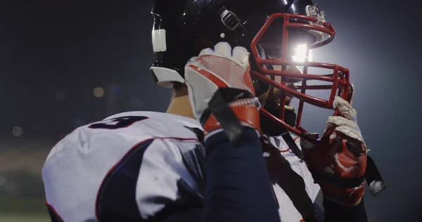 American Football Spieler Setzt Schutzhelm Gegen Helle Stadionbeleuchtung Auf — Stockfoto