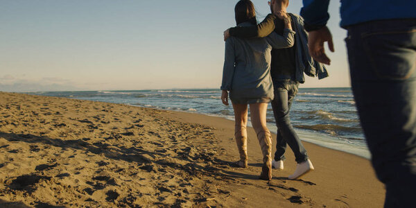 Group Of Young Friends Spending The Day On A Beach during autumn day