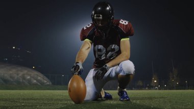 american football kicker ready for football kickoff closeup shot on the night field clipart
