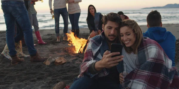 Coppia Utilizzando Telefono Cellulare Durante Festa Spiaggia Con Gli Amici — Foto Stock