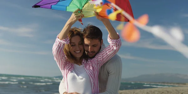 Casal feliz se divertindo com pipa na praia — Fotografia de Stock