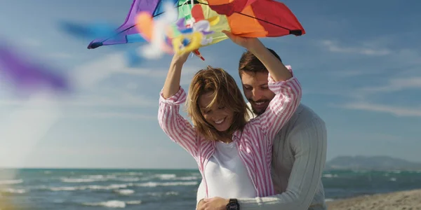 Gelukkige paar plezier met kite op het strand — Stockfoto