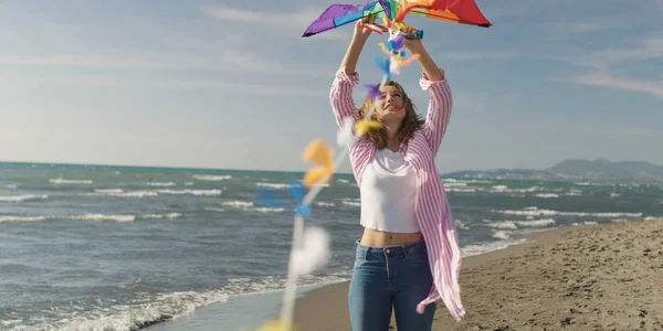 Lycklig kvinna ha kul med drake på stranden — Stockfoto