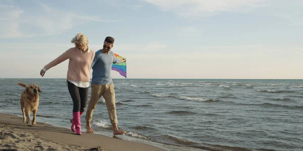 Couple avec chien s'amuser sur la plage le jour de l'autmun — Photo