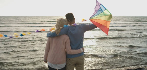 Happy couple having fun with kite on beach — Stock Photo, Image