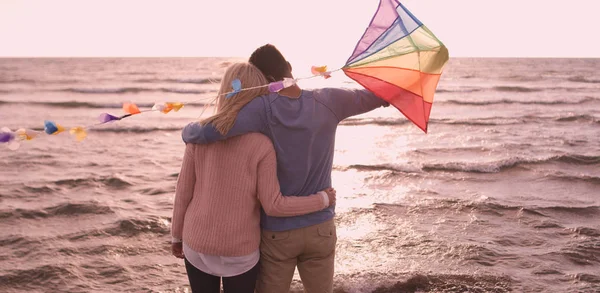 快乐的情侣在沙滩上玩风筝 — 图库照片