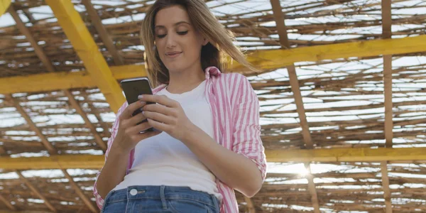 Smartphone femme textos sur téléphone portable à la plage — Photo