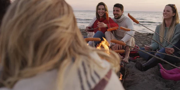 Grupo Jóvenes Amigos Sentados Junto Fuego Tarde Noche Asando Salchichas — Foto de Stock