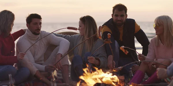 Grupo Jóvenes Amigos Sentados Junto Fuego Tarde Noche Asando Salchichas — Foto de Stock