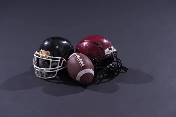 Amerikaans voetbal en helmen geïsoleerd op grijs — Stockfoto